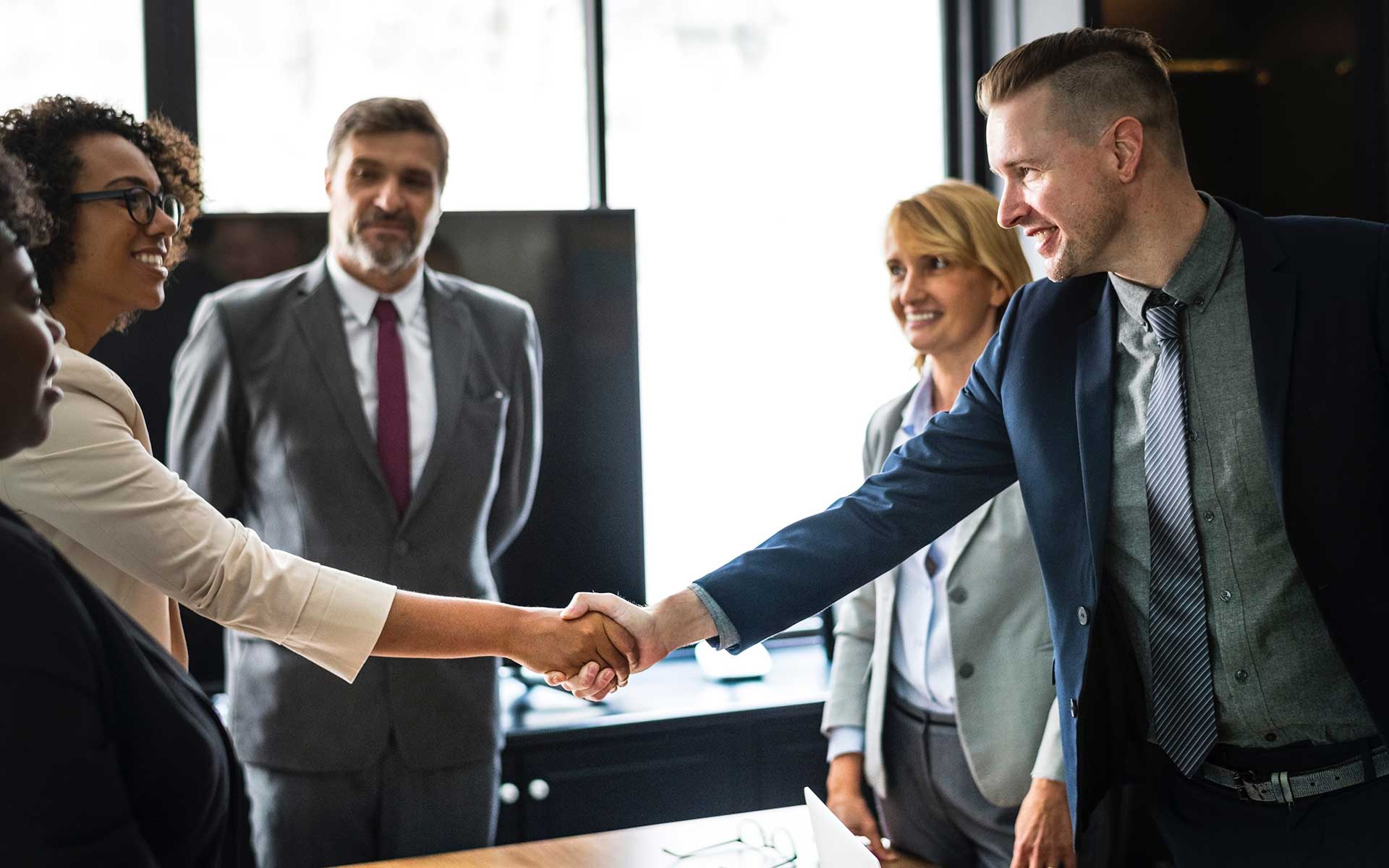 A group of people shaking hands in an office.